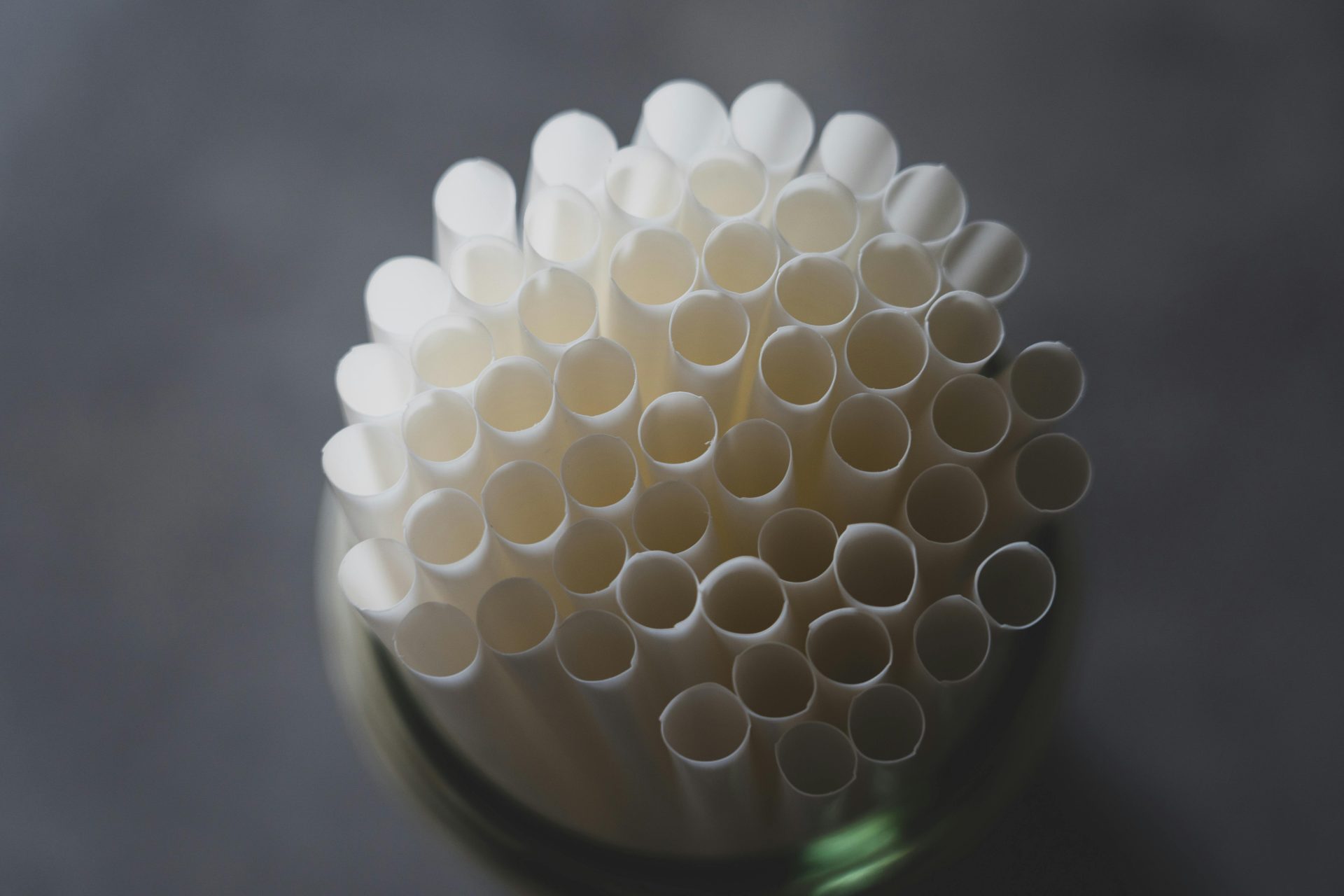 A top view of a bundle of eco-friendly white paper straws in a container.
